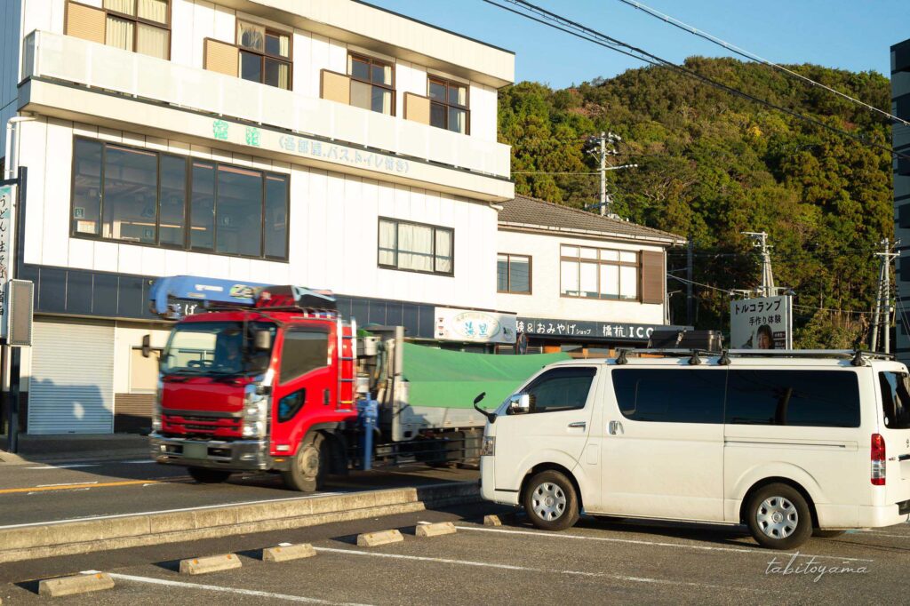 朝の道の駅くしもと橋杭岩に駐車するハイエース、目の前の道路を車が通過していく