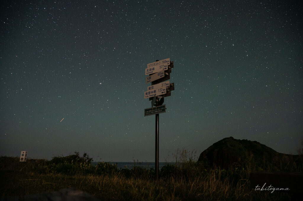 二ツ亀キャンプ場から眺める星空、風王には看板と後ろには二ツ亀のシルエットが見える