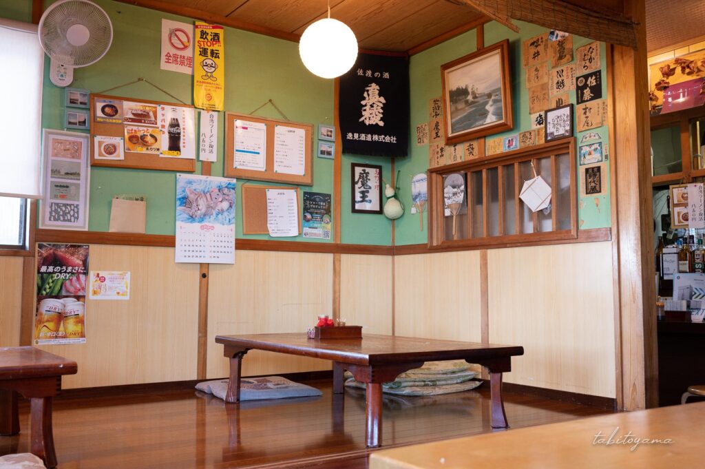 佐渡ヶ島にある上生カツ丼が有名な春日の店内小上がり、写真やカレンダーなど賑やかな壁面