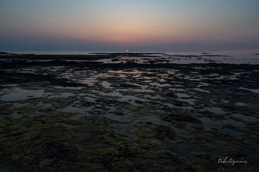 万千畳のマジックアワー、水平線に夕日が沈みそうになる、斑模様の海底に空のグラデーションが反射する