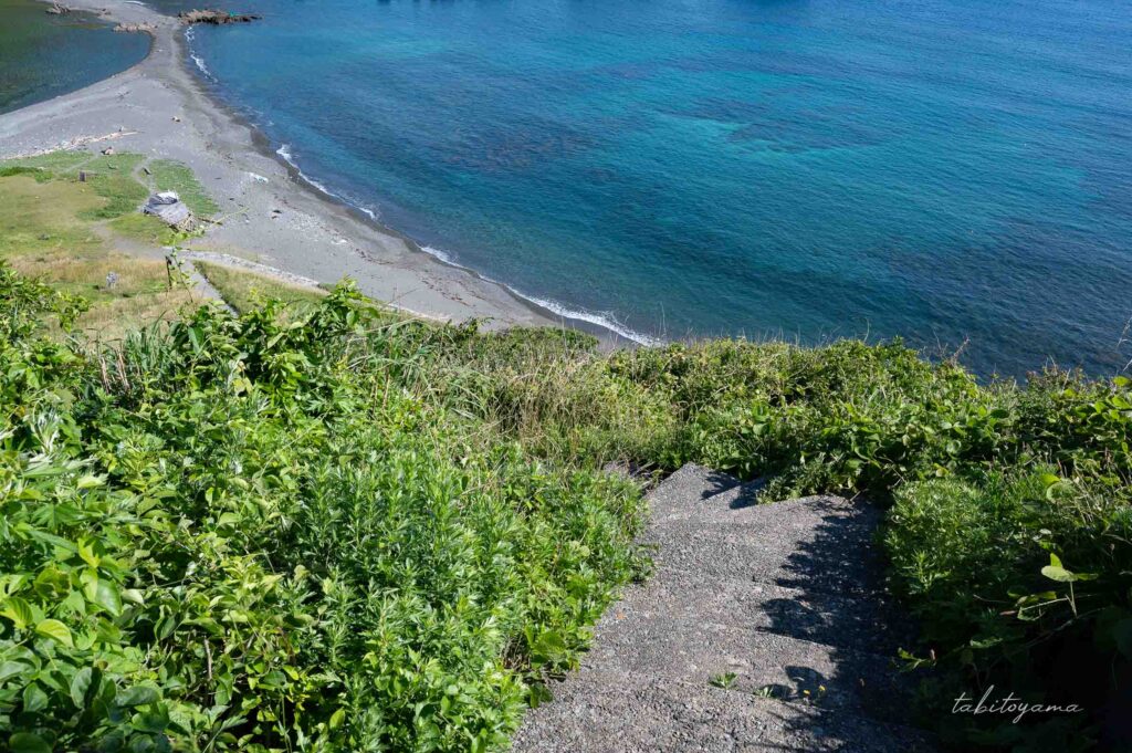 二ツ亀キャンプ場から海水浴場へと続く坂道を下る、視線の先には青い海が広がる