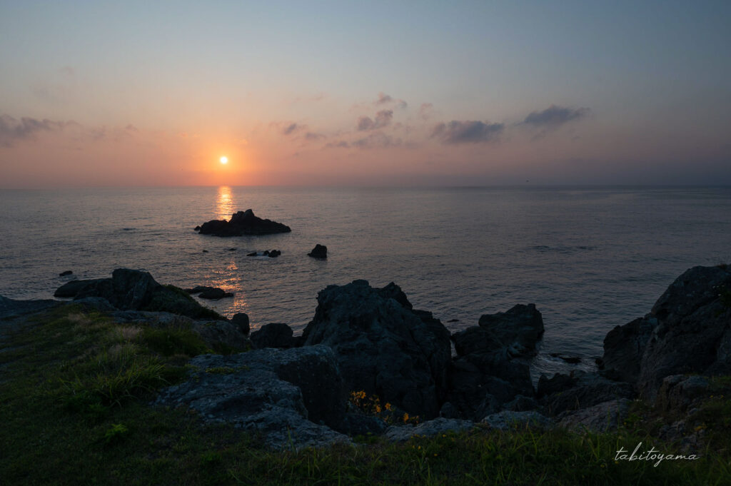 春日先から水平線に沈む夕陽を眺める