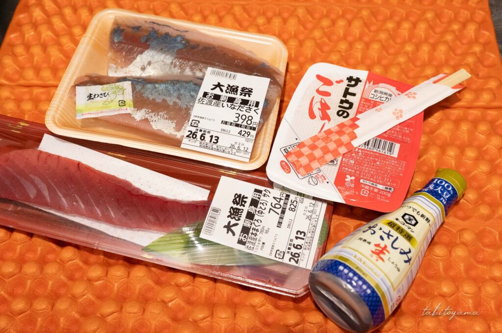 刺身の柵と醤油、サトウのごはんが登山マットの上に並べられている