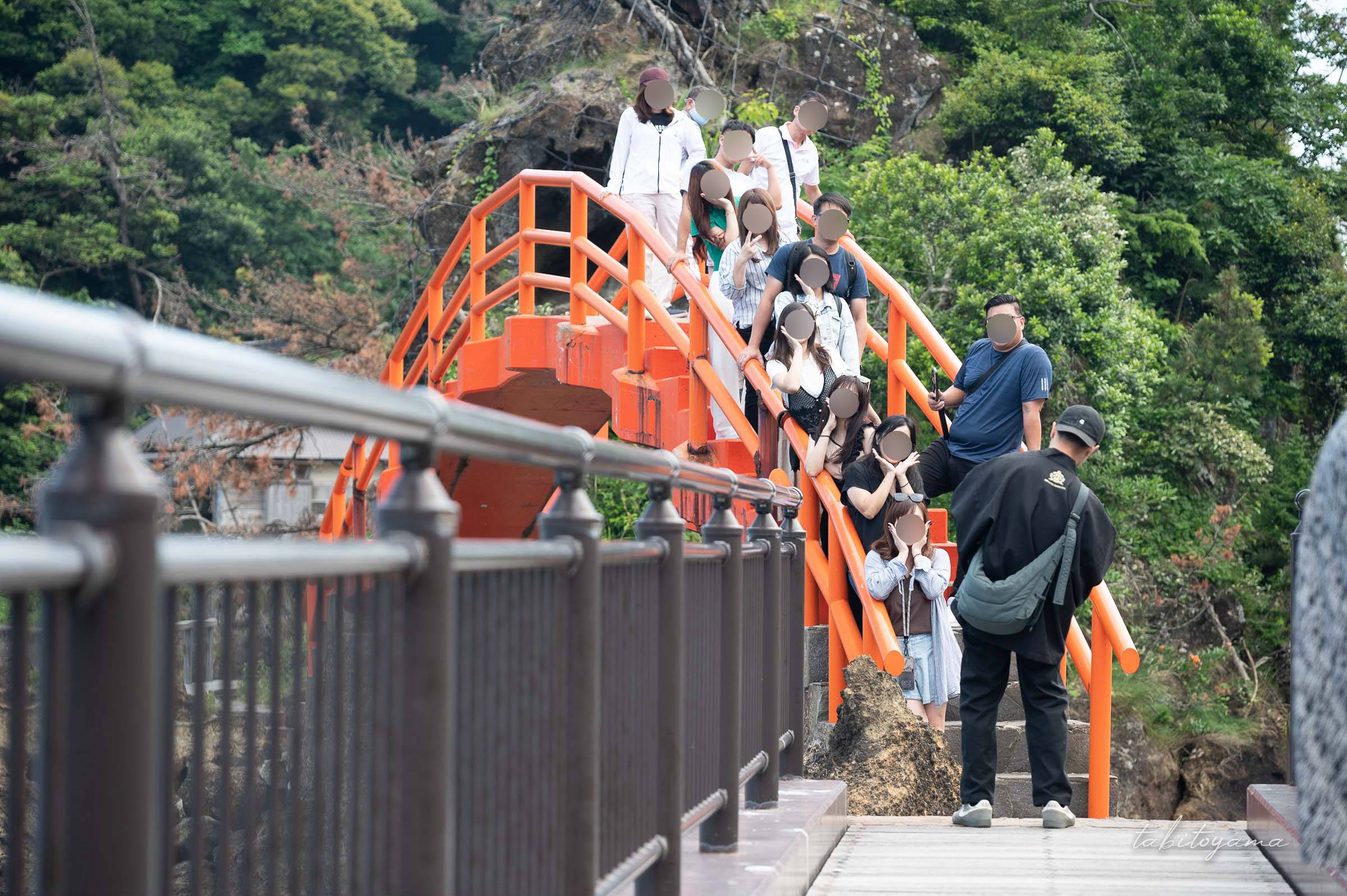 矢島・経島の太鼓橋の上で記念撮影をするインバウンドの団体客