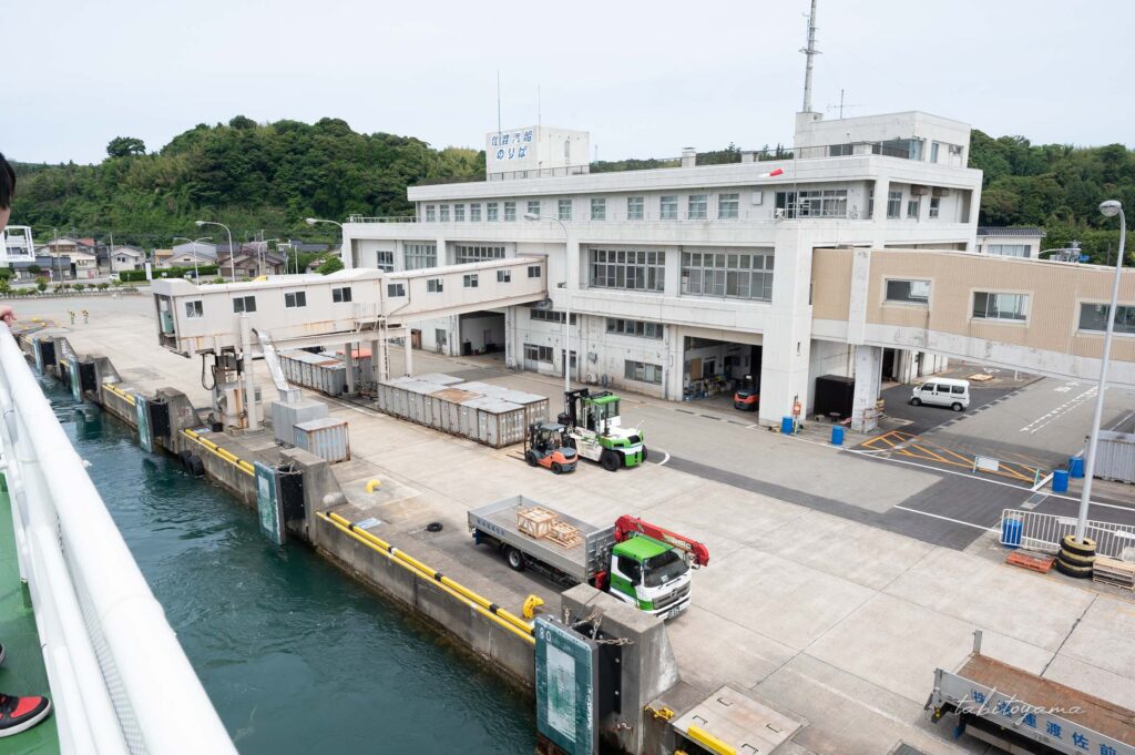 離岸直後のフェリー船上デッキから離れていく小木港を眺める