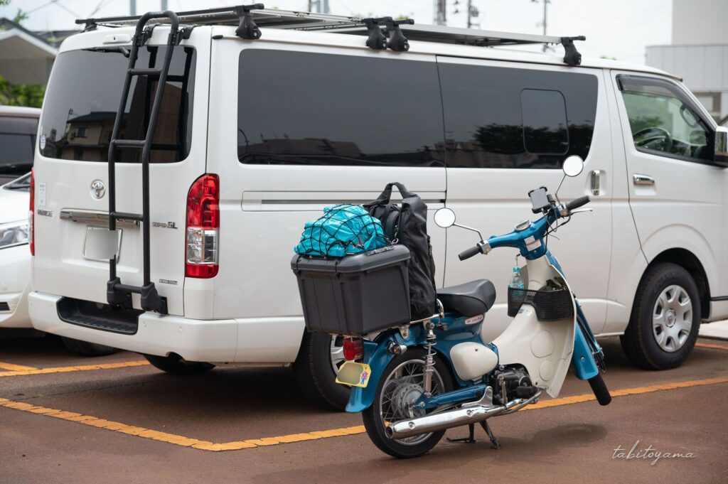 コインパーキングに駐車したハイエースの隣には荷物を積載したリトルカブ