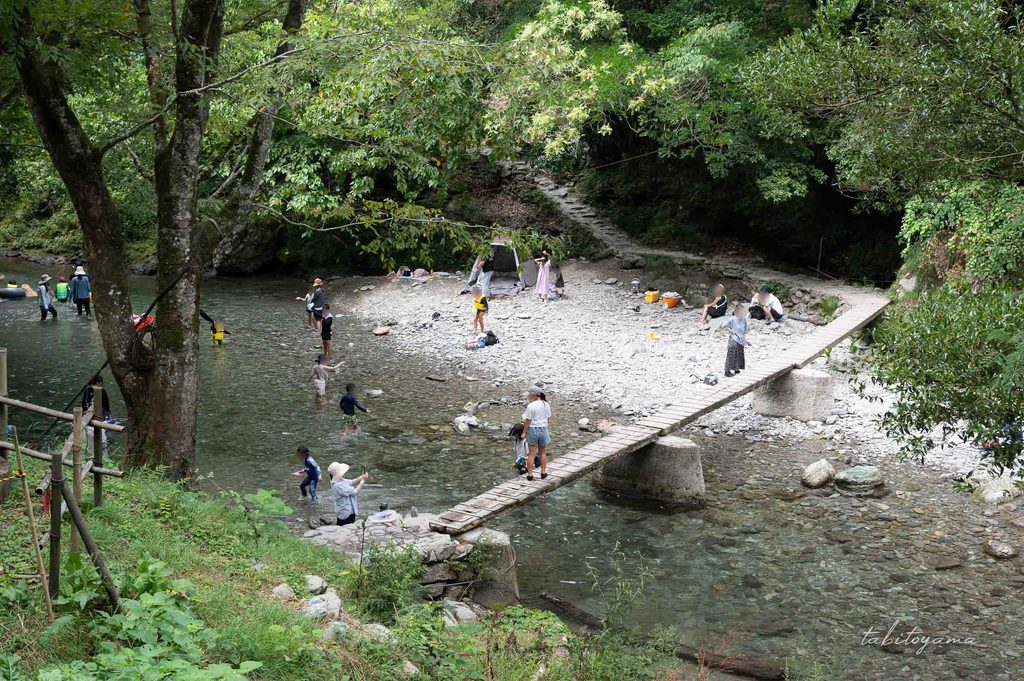 馬立川と道の駅 霧の森を繋ぐ小さな木製橋の周辺で遊ぶ子供とその家族たち