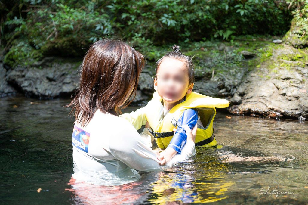 馬立川の水深の深い場所で水に浸かる妻と強張った表情の息子