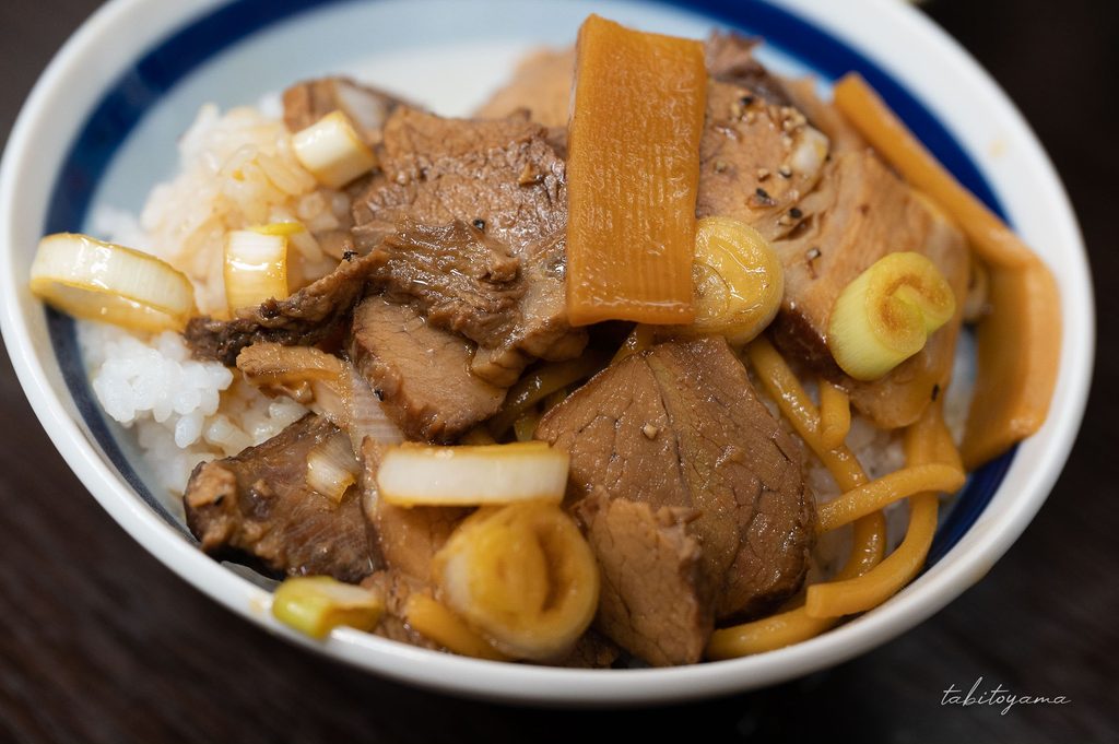 富山ブラックの麺や具材を生卵にくぐらせてご飯に乗せる