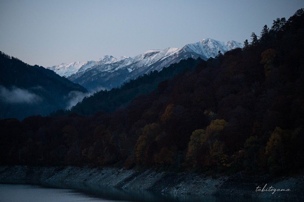 明け方の黒部ダムのえん堤から眺める冠雪した立山連峰