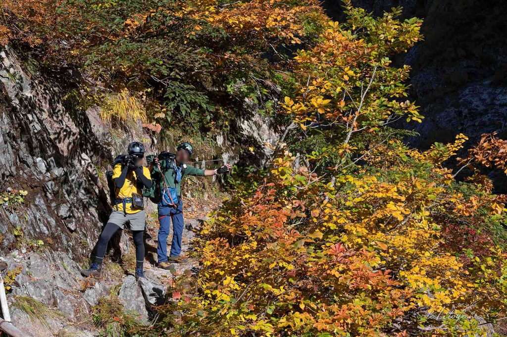 こちらに視線を向けてポーズを取る登山者