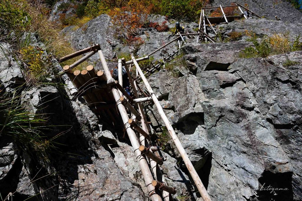 大ヘツリの急はしごを登る登山者