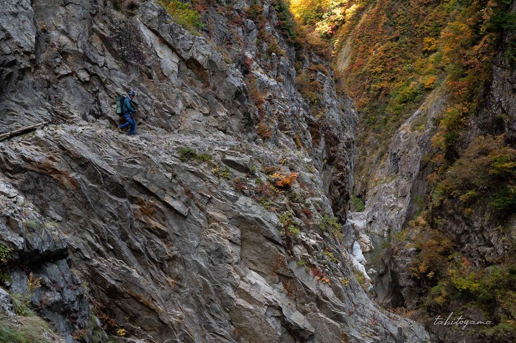 白竜峡の岸壁沿いの登山道を歩く登山者