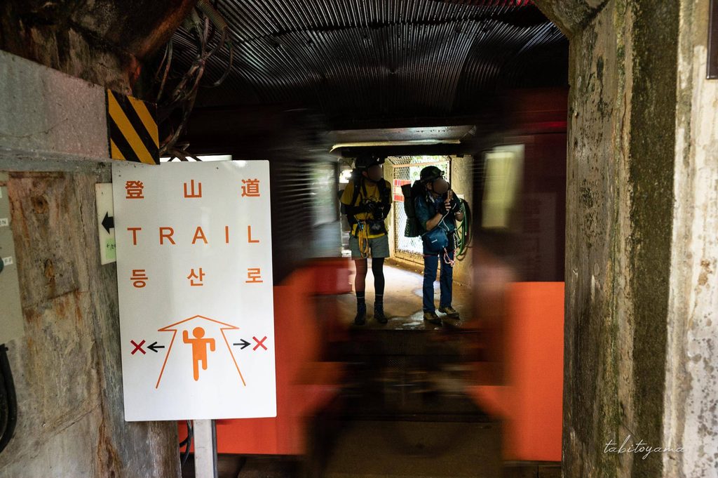 仙人谷ダム内を走る関西電力のトロッコ列車を見送る登山者