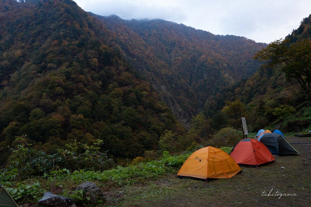 紅葉した山々と設営されたテント