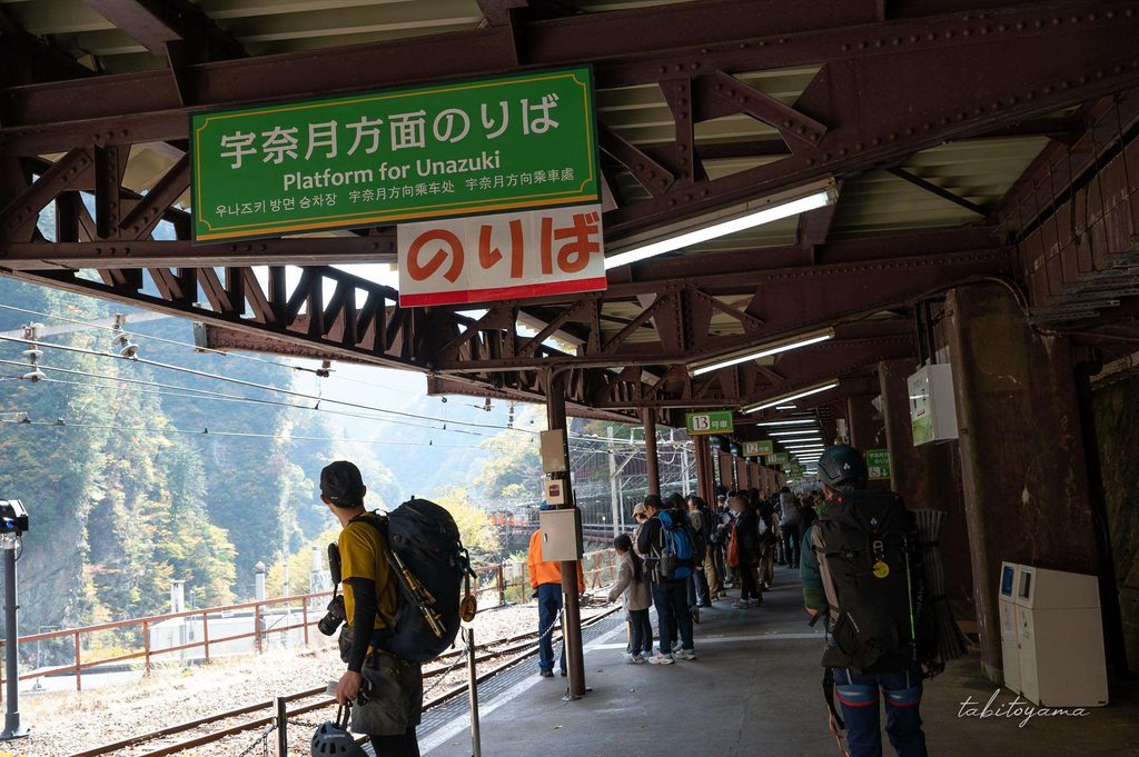 欅平駅の宇奈月方面のりばで列車を待つ登山者