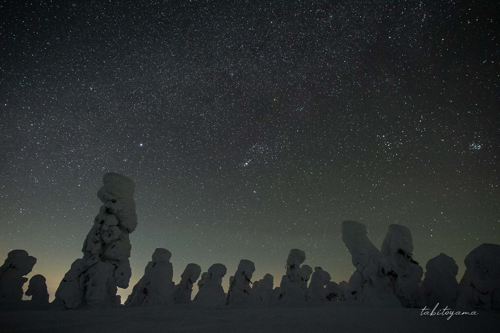 西吾妻山の樹氷越しに見える星空と、地平線付近に淡くにじむ街明かり